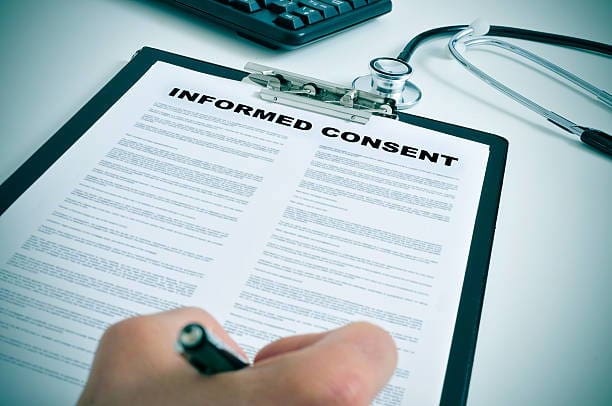 patient signing an informed consent in a doctors office